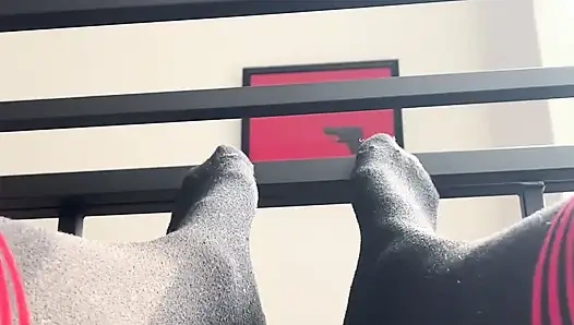 Diz yüksek çoraplı kafesli köle kız ayaklarını barlara sürttüruyor