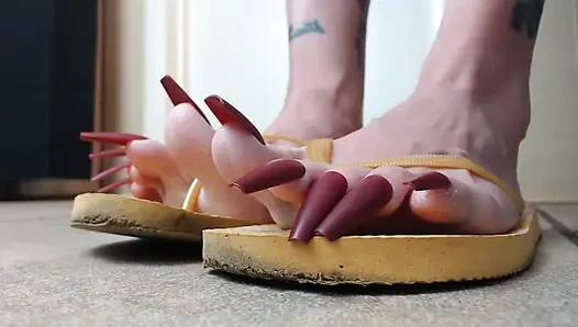 Toenails sarı parmak arası terliklerini sallıyor