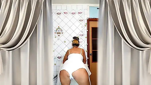 Real home solo of a mature woman in a small cozy kitchen.