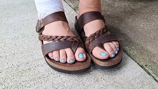 Salıncakta sallanıyor beni yok sayıyor ve deri sandaletleriyle oynuyor