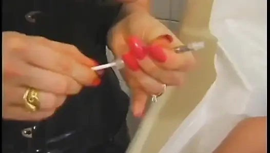 Deri giyen genç kız göğüslerine iğne alıyor