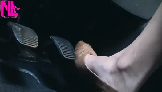 Açık kahverengi gözetleme toynağı sandaletle canlanıp araba sürüyor