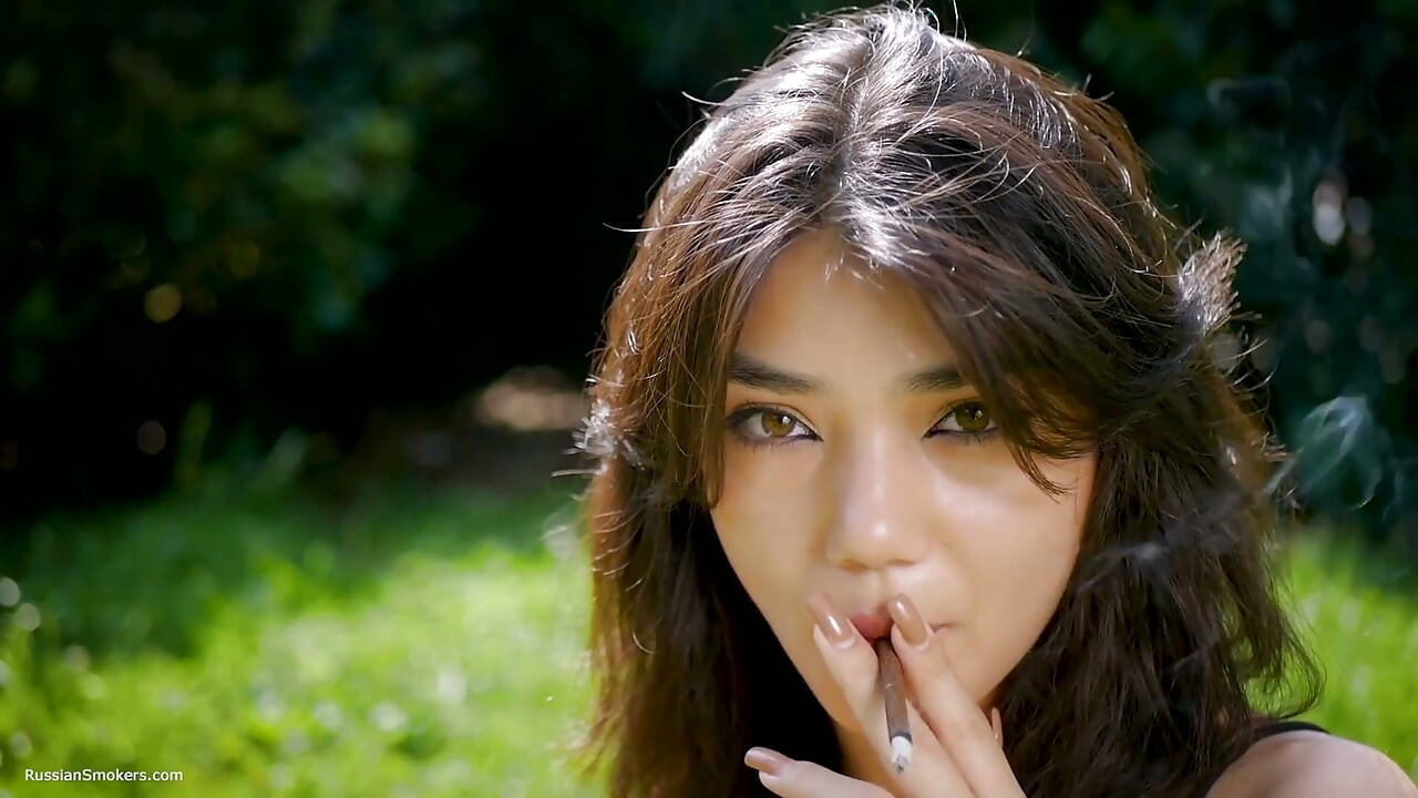 Arina açık havada bir siyah sigara içiyor