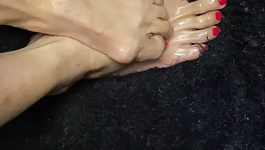 Kırmızı ayak tırnaklı cilalı yağlanmış seksi minik ayaklar