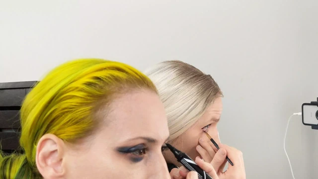 Travesti ve kadın göz kapağını takıyor