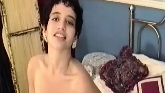 Esmer kadın yatakta soyunuyor ve soyunuyor
