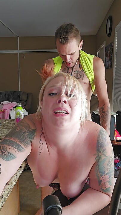 Husband sneaks in on wife doing dishes