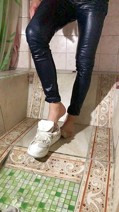 Wetting myself and soaking wet at the bathroonm in blue jeans, coral color t-shirt and white sneackers