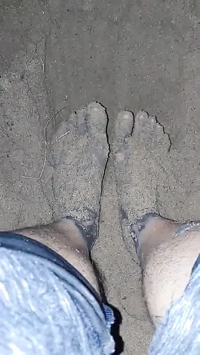 Çıplak ayaklar kumda oynuyor