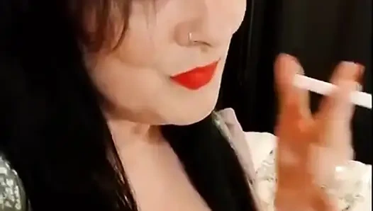 Sevimli sigara içen orta yaşlı seksi kadın kırmızı ruj