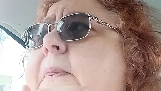 İri güzel kadın arabasında pembe kazak içinde sigara içiyor hayranlarıyla konuşuyor