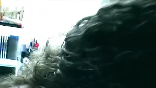 Kıvırcık esmer ofis sandalyesinde sert biniyor