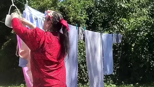 Dışarıda çamaşır asmak için klasik bir elbiseyle giyindi