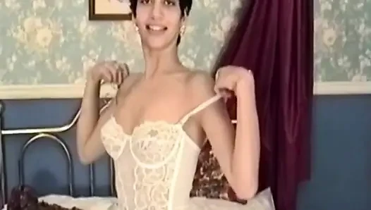 Esmer kadın yatakta soyunuyor ve soyunuyor