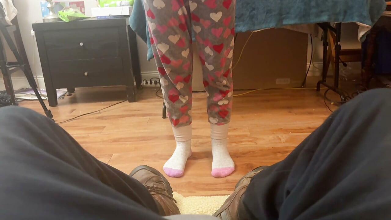 girl takes cares of mans feet after work. she takes off his boots and socks and smells them deeply