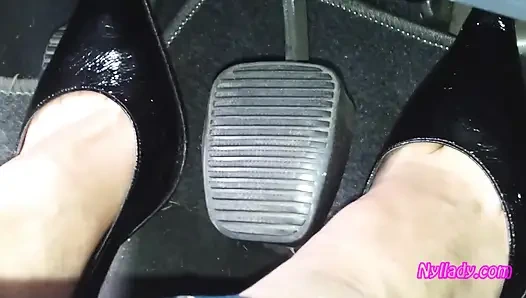 Conducir y revving en bombas negras a pie desnudo