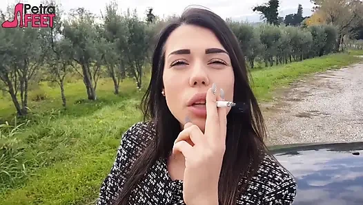 Seksi esmer kadın açık havada sigara içiyor