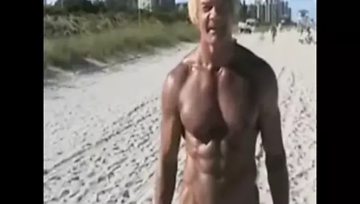 Yaşlı bir adam çıplaklar plajına büyük beyaz bir horoz gösteriyor