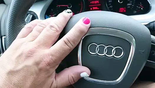 Çapraz giyinmiş parlak naylon çoraplar, elbise ve topuklular araba sürüyor.