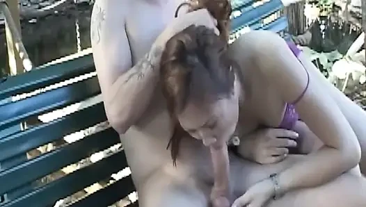 Olgun esmer orta yaşlı seksi kadın açık havada ıslak bankta sakso çekiyor