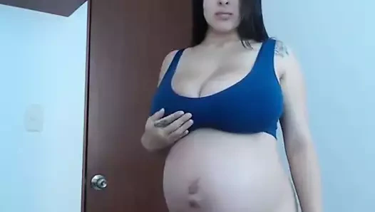 Hamile kadın kendini kamerada gösteriyor.