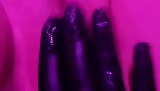 Pembe ışıklar altında lateks eldiven kedi masajı