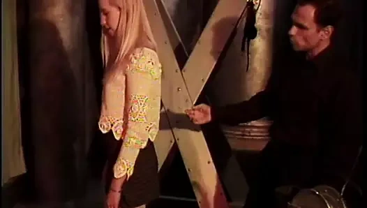 Seksi sarışın kırmızıya bağlı ve sadist tarafından uygulanan kelepçelere sahip