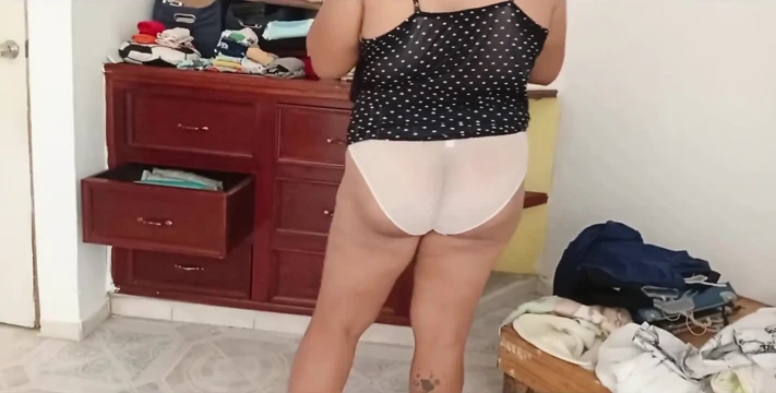 Tombul kız odayı topluyor ve kıyafetlerini katlıyor