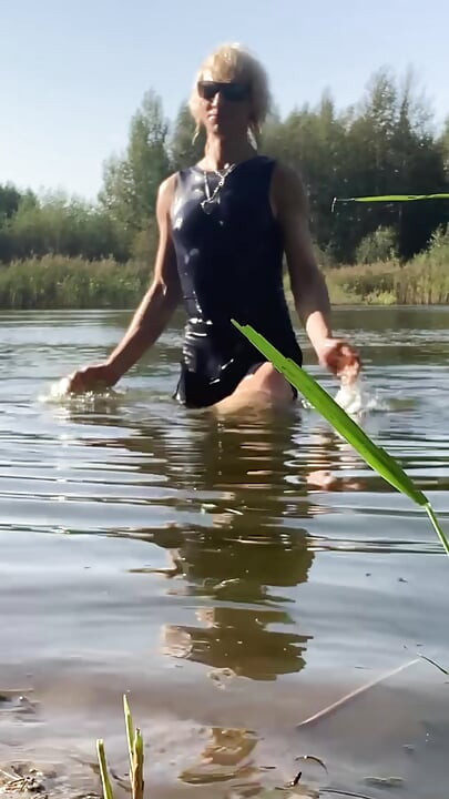 Trans kız mavi spor elbisesi içinde gölde yüzer. Wetllok trans kız ıslak.