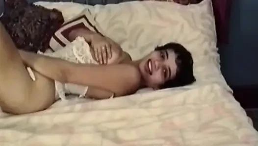 Esmer kadın yatakta soyunuyor ve soyunuyor