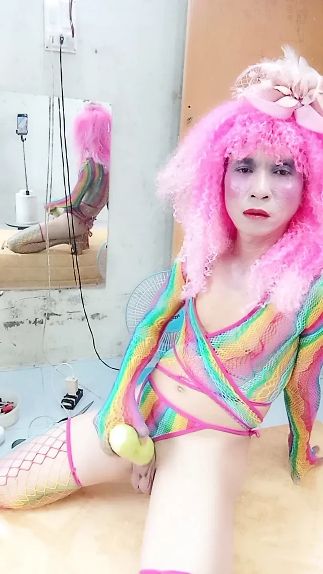 Transgender Le seksi kıyafetler giyiyor ve yapay göğüslerle seks kupaları oynuyor.