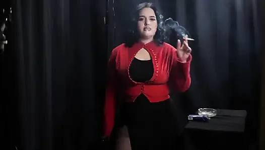 Tombul esmer kırmızı cardigan içinde sigara içiyor
