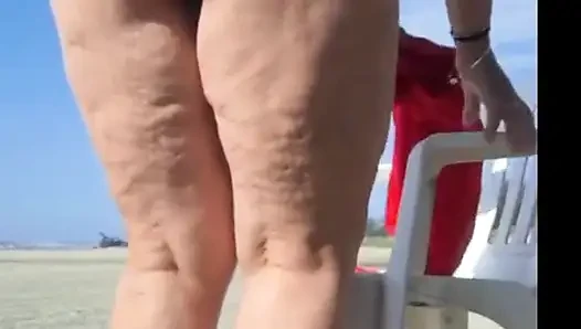 Hot crown sunbathing on the beach in transparent micro bikini