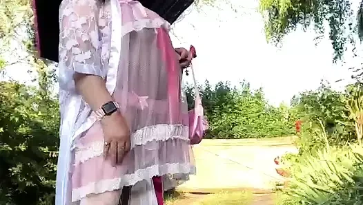 Pembe gecelikli ve güneşlikli daha dolgun beyaz elbiseli bir kıyafet içinde