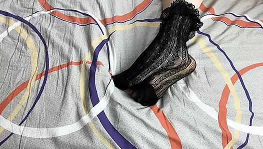 Siyah dantelli çoraplı kızın uzun bacaklarını okşuyor