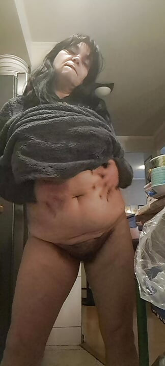 Orta yaşlı seksi kadın mutfakta ateşli amcığıma dokunmak ve yemek pişirmek arasında
