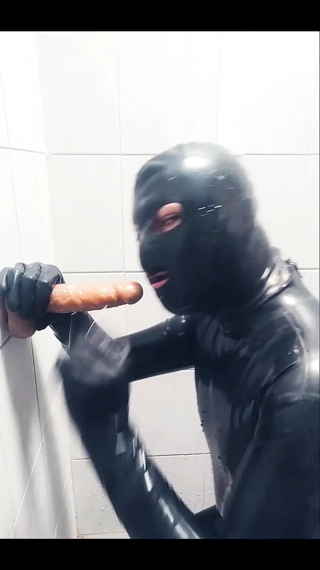 Rubber boy playing with a dildo in chastity p1