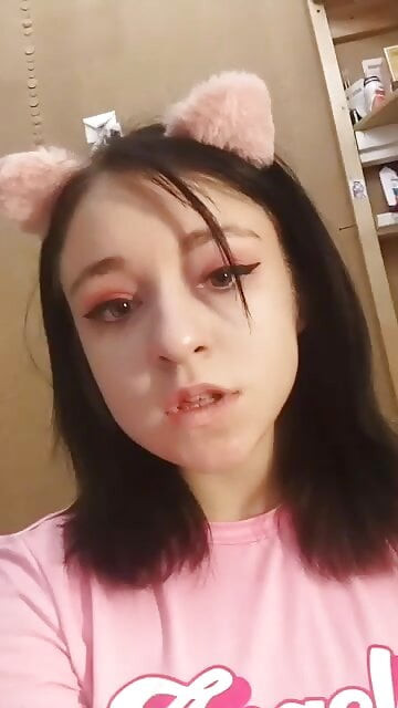 Pembe bir tişörtle gündüz evde striptiz yapıyor ve güzel göğüslerini sergiliyor. yakın çekim