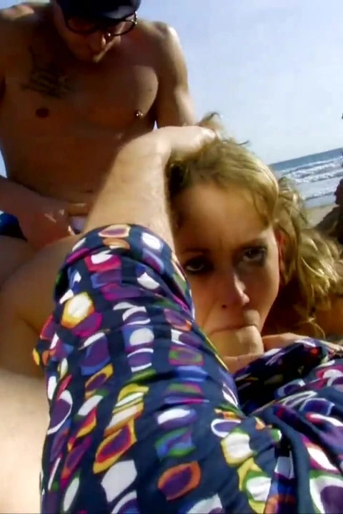 Genç kız plajda güneşleniyor, iki adam tarafından tavlanıyor ve sikiliyor