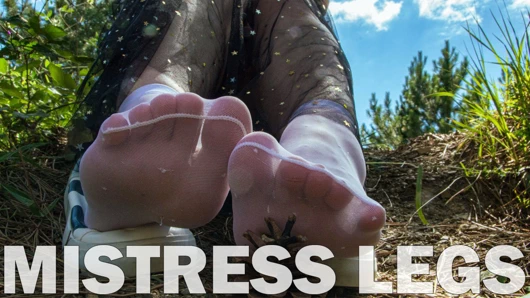 Ormanda beyaz naylon çoraplarda kıpırdayan sevimli tabanlar ve ayak parmakları