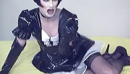 Ağır makyajlı ve pvc hizmetçi kadın kılıklı sürtük sigara içiyor ve kendini gösteriyor