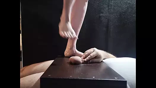 Yalınayak taşak ezme topu top ezme masasında duruyor