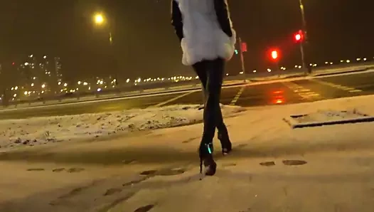 Sıcak deri tozluk ve yüksek topuklu açık havada yürüyen kız