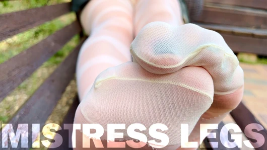 Beyaz desenli külotlu çoraplı bir bankta baştan çıkarıcı naylon ayakların tadını çıkarın