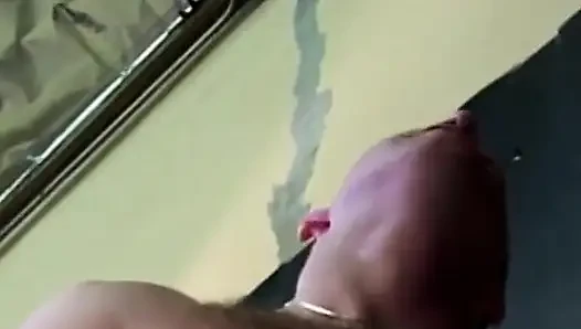 Dalgalı saçlı sürtük adam sandalyede otururken sakso çekmenin tadını çıkarıyor