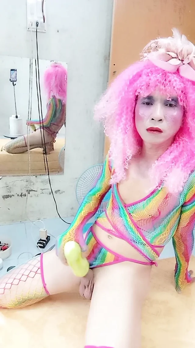 Transgender Le seksi kıyafetler giyiyor ve yapay göğüslerle seks kupaları oynuyor.