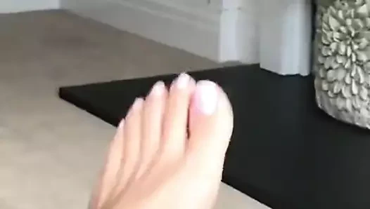 Ayaklar beyaz oje ile ayak tırnaklarıyla oynuyor