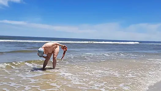 Amatör film. Bir nüdist okyanus kıyısında dalgalarla oynuyor.