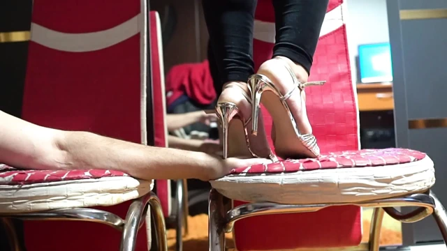 Ellerinde topuklu ayakkabılarla ayaklar altına alıyor