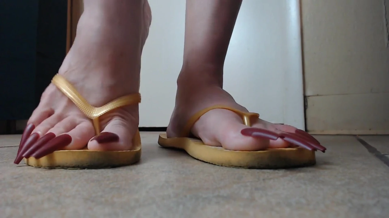 Toenails hanging off yellow flip flops